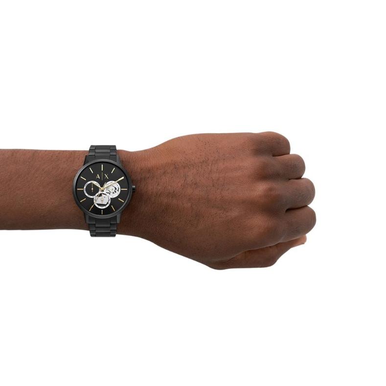 Wearing View Of Armani Exchange AX2748 Cayde Men's Analog Watch featuring a black dial with white accents, stainless steel case, and black and rose gold bracelet. Includes day and date functions with 50M water resistance.