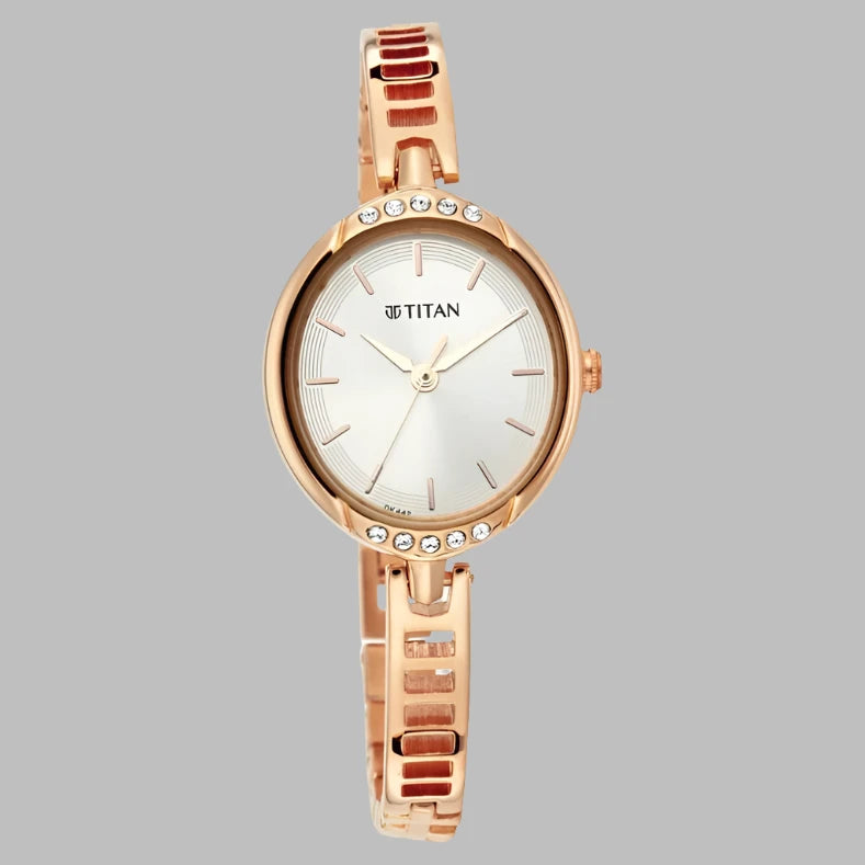 Titan 2637WAA Quartz Analog Women's Watch with a silver-patterned dial, rose-gold crystal-embellished case, and a sleek metal bangle strap.