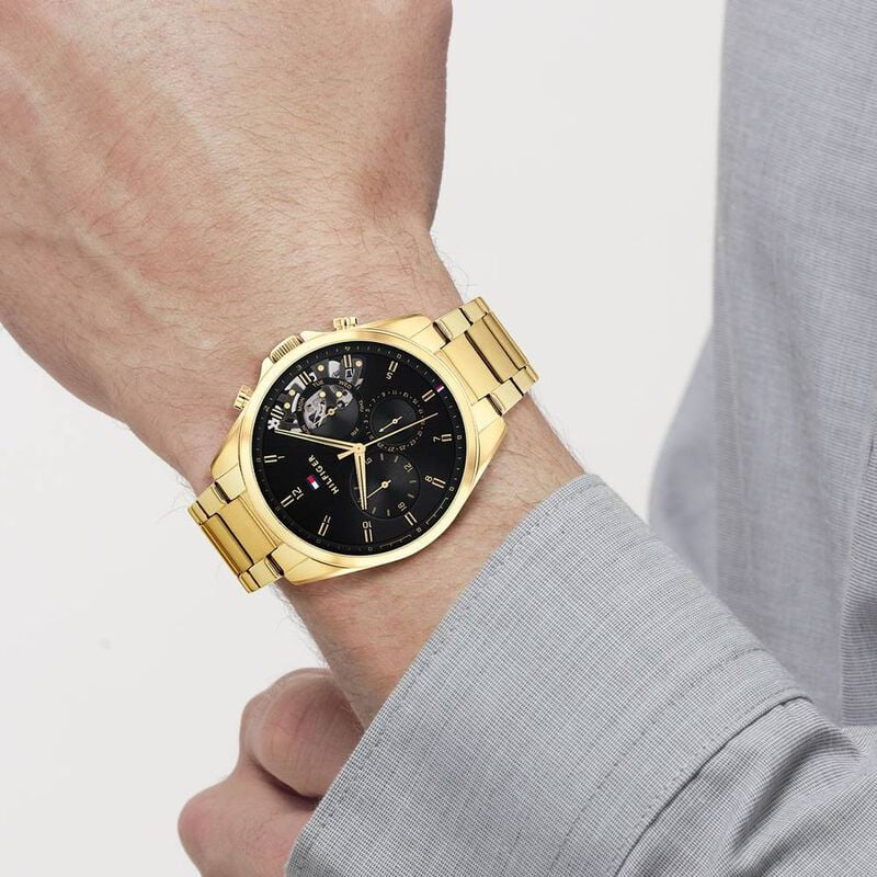 Wearing View Of Tommy Hilfiger 1710447 Men's Watch with Black Dial, Gold-Tone Stainless Steel Case, and Bracelet