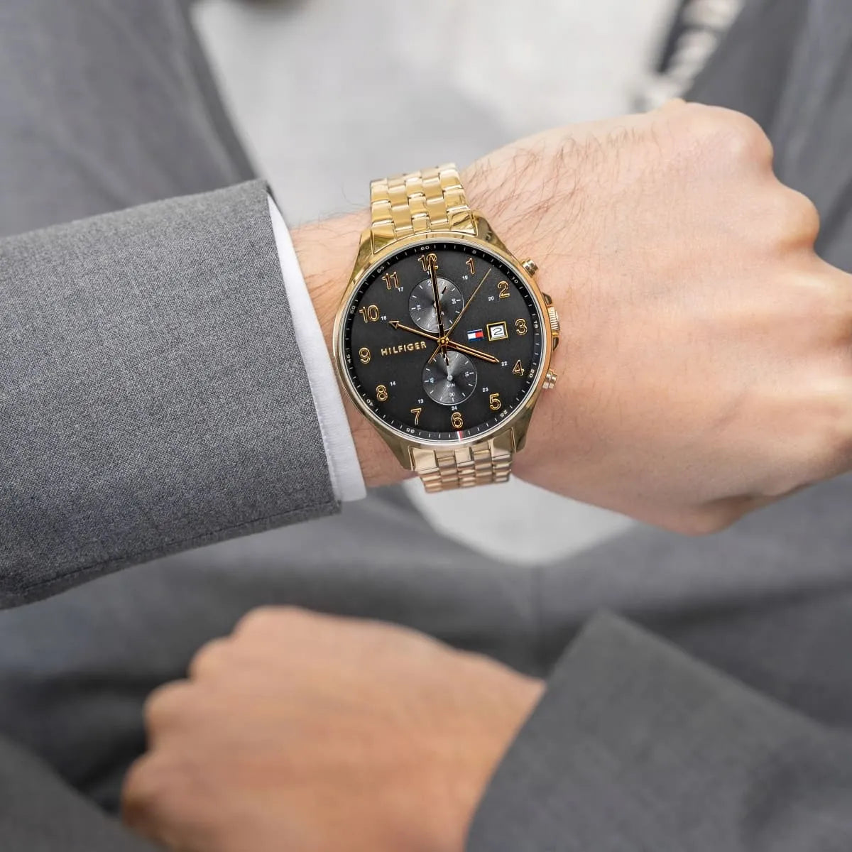 Wearing View Of Tommy Hilfiger 1791708 Men's Watch with Black Dial, Gold Accents, and Black Stainless Steel Strap