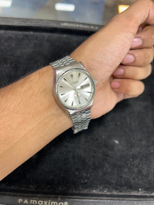 Wearing View Of Vintage Citizen Automatic 21 Jewel Men's Wristwatch with Silver Radiant Dial, Calendar, and Stainless Steel Case and Band.