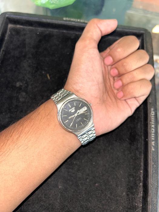 Wearing View Of Vintage Seiko 5 Automatic Wrist Watch with black dial, gold-plated stainless steel case, day/date display, and bracelet strap