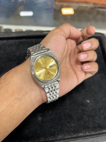 Wearing Look Of Vintage Seiko 5 Automatic Men's Wristwatch with Salmon Dial, Day/Date Display, Polished Stainless Steel Case, and 17 Jewel Movement.