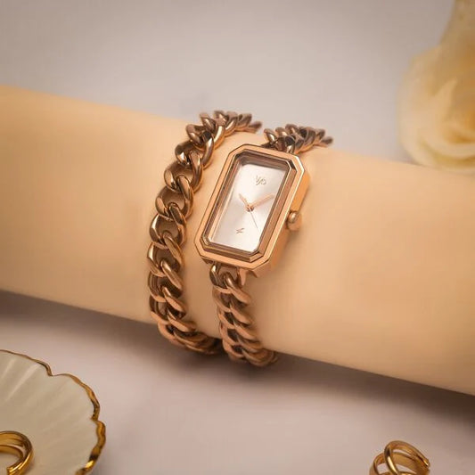 A rose gold metal chain strap watch with a silver dial, displayed on a woman's wrist VYB by Fastrack women’s trendy watch.