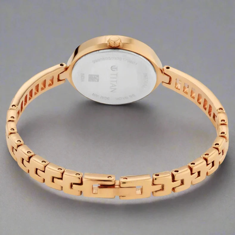 Back View Of Titan 2637WAA Quartz Analog Women's Watch with a silver-patterned dial, rose-gold crystal-embellished case, and a sleek metal bangle strap.